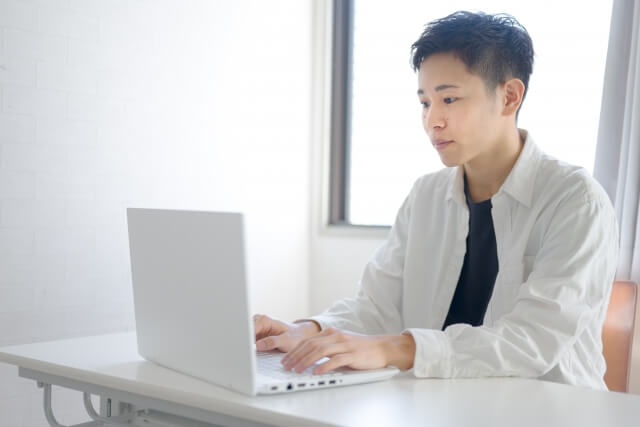 ノートパソコンを使う若い男性